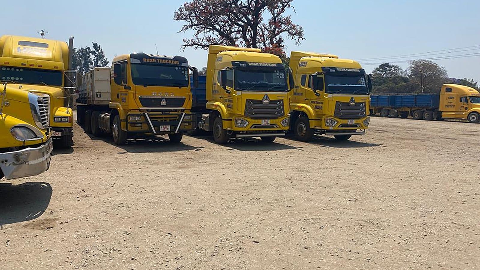Rush Trucking yellow fleet lined up at the yard under a wide Zambian sky